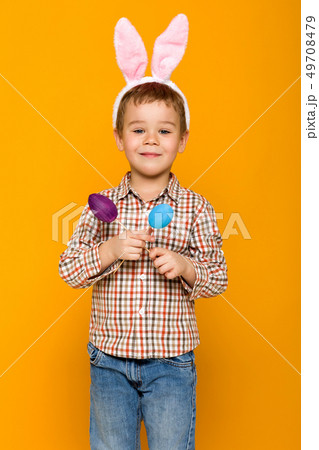 little child boy with Easter bunny ears holding colorful eggs 49708479