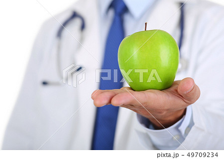Male medicine therapeutist doctor hands holding green fresh ripe apple Male medicine therapeutist doctor hands holding green fresh ripe apple 49709234