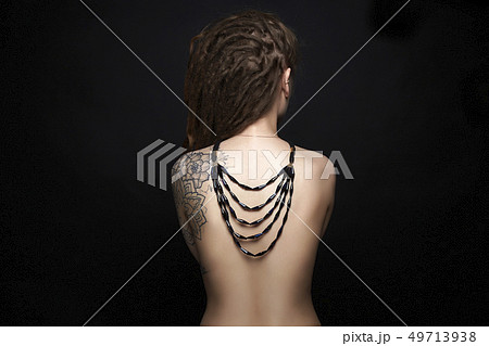 naked Girl with tattoo and necklace on her back naked Girl with tattoo and necklace on her back 49713938