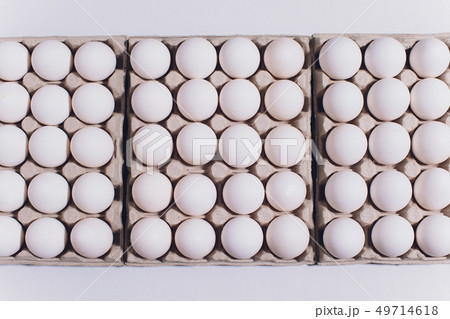 White eggs of a hen in harmless, cardboard packing on a white background. White eggs of a hen in harmless, cardboard packing on a white background. 49714618