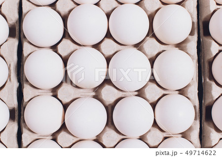 White eggs of a hen in harmless, cardboard packing on a white background. White eggs of a hen in harmless, cardboard packing on a white background. 49714622