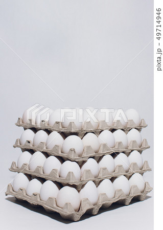 White eggs of a hen in harmless, cardboard packing on a white background. 5 packs. White eggs of a hen in harmless, cardboard packing on a white background. 5 packs. 49714946