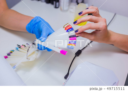 Nail technician shows the color palette of nail services in beau 49715511