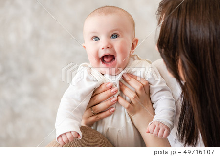 Cute infant girl smile in mama hands Cute infant girl smile in mama hands 49716107