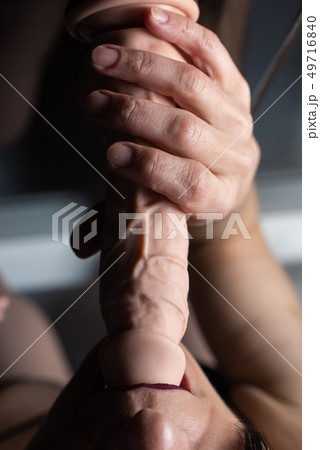 Close-up of female mouth with rubber dildo 49716840