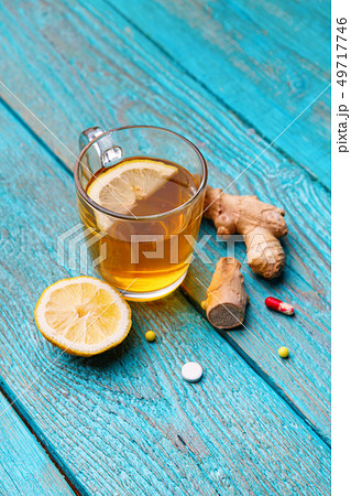 Cold medicines, tea, lemon and ginger on wooden blue background 49717746