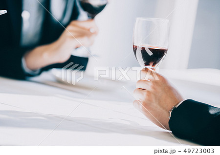 レストランでワインを飲む上司と新入社員の手元 49723003