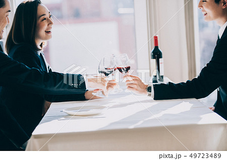 レストランで上司たちと乾杯する新入社員の女性の手元 49723489