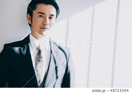 白壁を背景に立つ上司の男性 49723504