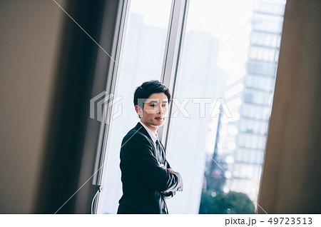 窓際に佇む新入社員の男性 49723513