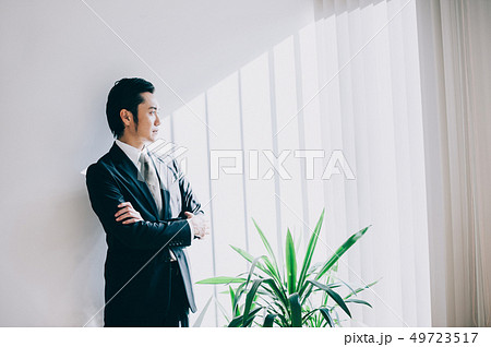 白壁を背景に腕をを組む上司の男性 白壁を背景に腕をを組む上司の男性 49723517