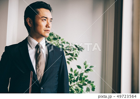 窓際でファイルを抱えて立つ上司の男性 窓際でファイルを抱えて立つ上司の男性 49723564