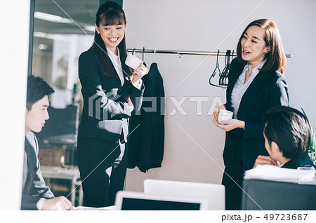 コーヒーを手に立つ女性たちと談笑する男性たち コーヒーを手に立つ女性たちと談笑する男性たち 49723687