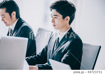 並んでパソコンに向かう上司と新入社員の男性 49723731