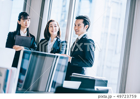 窓際に立ち談笑する上司と部下たち 窓際に立ち談笑する上司と部下たち 49723759