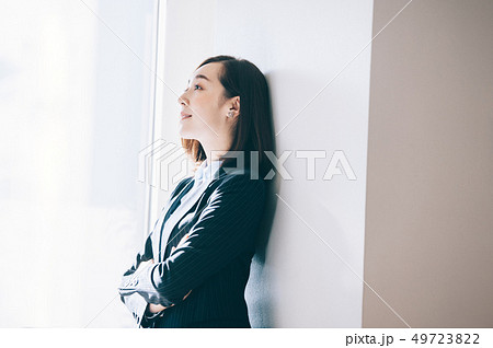 オフィスで柱にもたれ微笑む女性 49723822