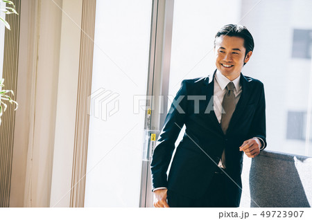 窓際に立ち微笑む上司の男性 窓際に立ち微笑む上司の男性 49723907