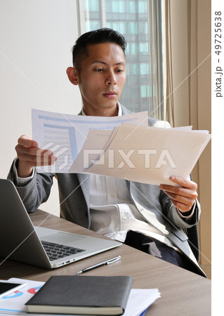 資料を見て疑問の浮かんだビジネスマン 49725638