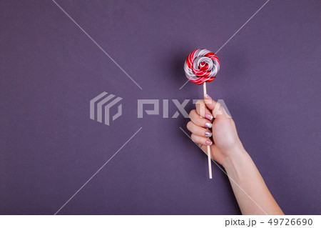 Lollypop on a stick in hand. Lollypop on a stick in hand. 49726690
