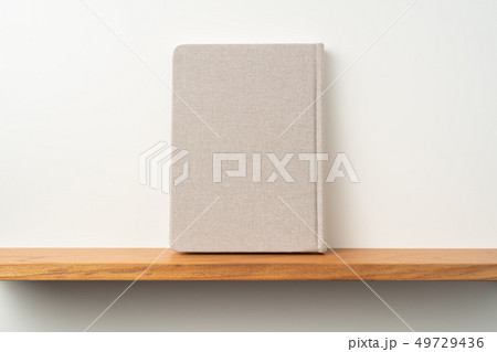 light red fabric notebook stand on bookshelf 49729436