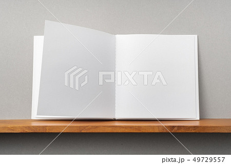 white square notebook on bookshelf and grey wall 49729557