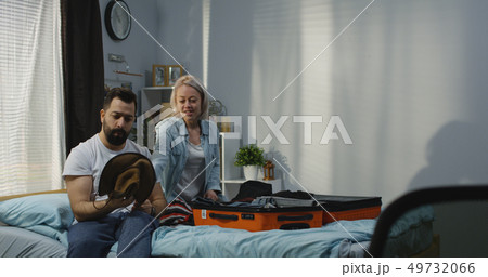 Couple packing in bedroom 49732066