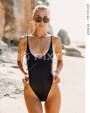 Attractive young woman in swimwear at ocean beach Attractive young woman in swimwear at ocean beach 49734169