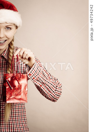 Happy shopping woman wearing Santa hat Happy shopping woman wearing Santa hat 49734242