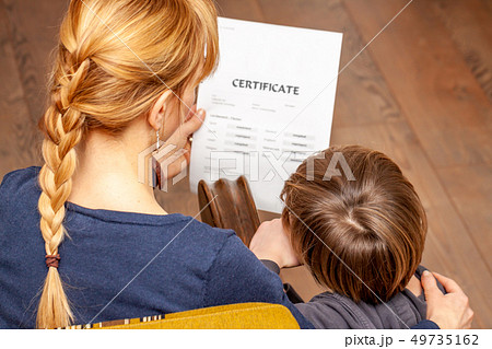 Mother comforting son despite the bad school certificate 49735162