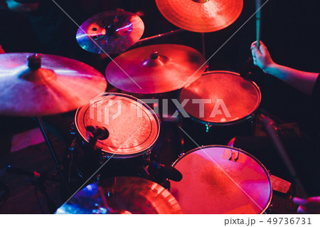 Drummer playing drum set at concert on stage. Music show. Bright scene lighting in club,drum sticks Drummer playing drum set at concert on stage. Music show. Bright scene lighting in club,drum sticks 49736731