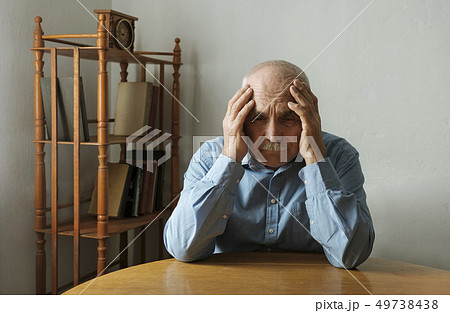 Worried elderly man with his head in his hands 49738438