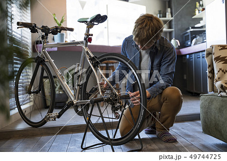 リビングで自転車の整備をする男性 49744725