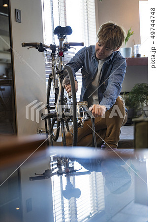 リビングで自転車の整備をする男性 リビングで自転車の整備をする男性 49744748