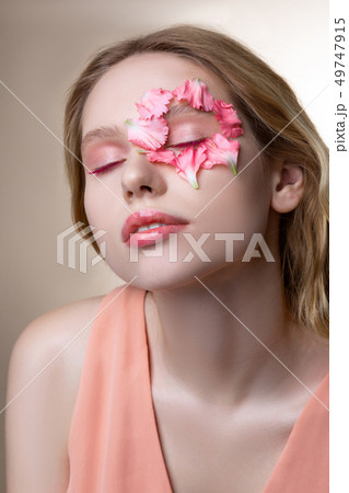 Blonde-haired model wearing pink dress having pink eyeshades 49747915