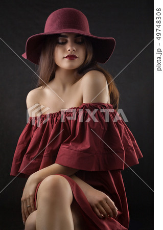 Brunette girl with long and shiny wavy hair . Beautiful model on dark background. 49748308