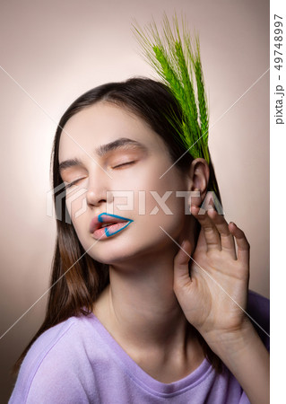 Dark-haired model with thick eyebrows closing eyes while posing 49748997