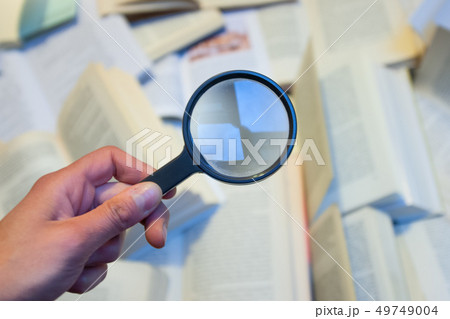 Magnifying glass to check various books 49749004