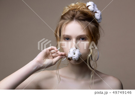 Good-looking young model with bare shoulders posing with cotton Good-looking young model with bare shoulders posing with cotton 49749146