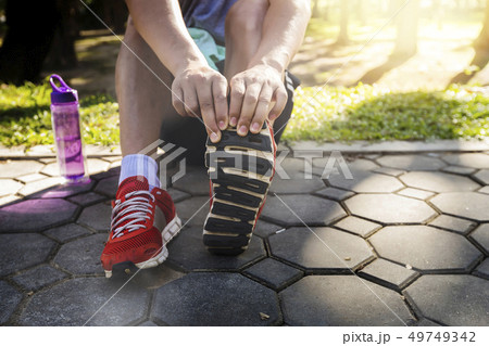 Asian athletes are stretching his legs Asian athletes are stretching his legs 49749342