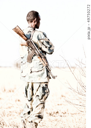 a black soldier and his gun looking the  boarder 49750272