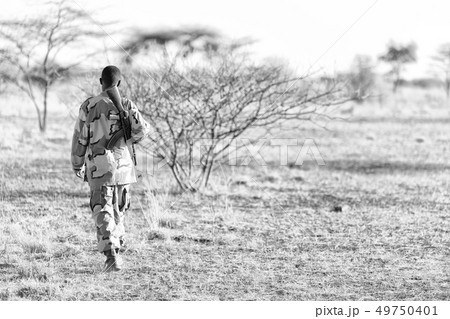 a black soldier and his gun looking the boarder a black soldier and his gun looking the boarder 49750401