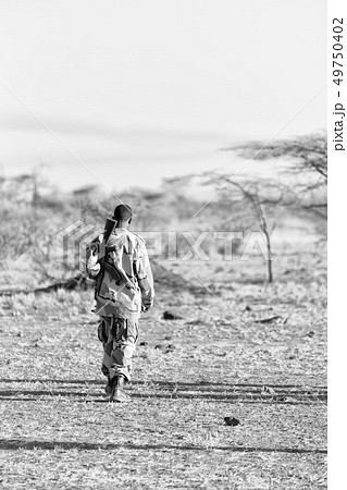 a black soldier and his gun looking the boarder a black soldier and his gun looking the boarder 49750402