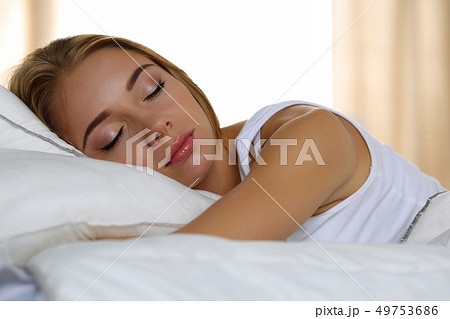 Young beautiful blonde woman portrait lying in bed sleeping 49753686