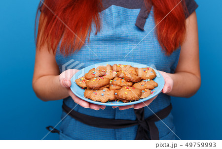 Woman with plate cookies in form rocket, ufo, alien and astronaut. 49759993