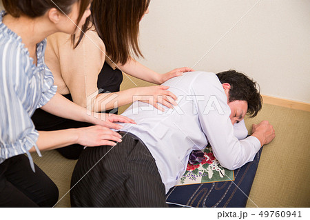 酔いつぶれる男性を介抱する 49760941