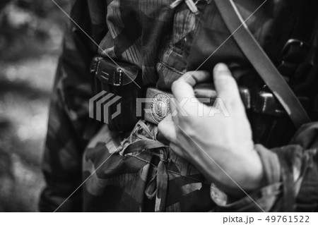 Re-enactor Dressed As World War II German Wehrmacht Soldier Holds His Hands On A Cartridge Belt Re-enactor Dressed As World War II German Wehrmacht Soldier Holds His Hands On A Cartridge Belt 49761522