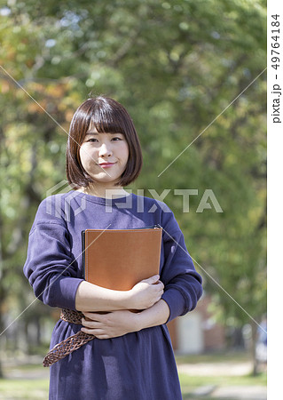 春の公園で書類を抱きかかえる学生 春の公園で書類を抱きかかえる学生 49764184
