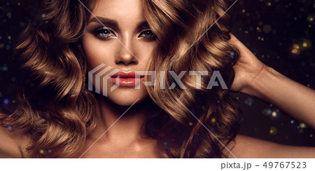 Beautiful young brunette with make up and curly hair Beautiful young brunette with make up and curly hair 49767523