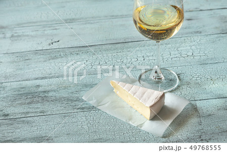 Glass of white wine with Brie 49768555