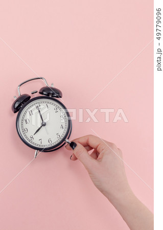 Female hand with alarm clock. Morning concept Female hand with alarm clock. Morning concept 49779096